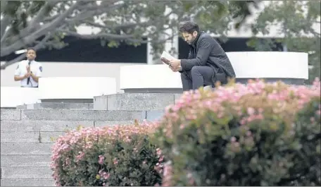  ?? Photograph­s by Brian van der Brug Los Angeles Times ?? LIBERTY PARK was designated as a historic-cultural monument last month. Above, a guard patrols the private property as a man reads.