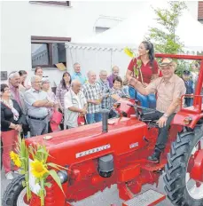  ??  ?? Oskar Rauser fährt unter charmanter Begleitung von Julia Baur mit dem McCormick, Baujahr 1962.