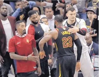  ?? TONY DEJAK/ASSOCIATED PRESS ?? LeBron James (23) is greeted by teammates after leaving Friday’s game against Golden State in which the Warriors won their third NBA title in four years.