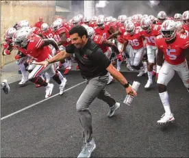  ?? DAVID JABLONSKI / STAFF ?? Ryan Day, filling in as Ohio State’s head coach with Urban Meyer suspended, leads his team onto the field Saturday for a game against Oregon State in Columbus.