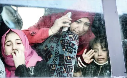  ??  ?? A Palestinia­n woman and child bid farewell through the window of a bus in Khan Younis in the southern Gaza strip on Saturday prior to their departure for the Rafah border crossing with Egypt. (AFP)