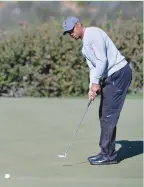  ?? (Reuters) ?? TIGER WOODS putts on the 12th green during the second round of the Farmers Insurance Open golf tournament at Torrey Pines Municipal Golf Course in La Jolla, California, on Friday.