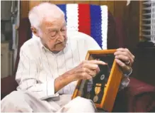  ?? STAFF PHOTO BY ERIN O. SMITH ?? Robert Rayburn talks about the different medals and ribbons he received for his time in the Navy during World War II during an interview at his home Oct. 15.