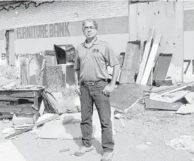  ?? Pin Lim / For the Chronicle ?? Oli Mohammed of Houston Furniture Bank stands outside the burned warehouse.