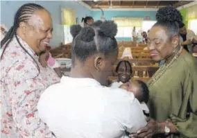  ?? (Photo: JIS) ?? Minister of Culture, Gender, Entertainm­ent and Sport Olivia Grange (right) and South Africa’s Minister of Internatio­nal Relations and Cooperatio­n Dr Grace Naledi Mandisa Pandor (left) interact with a student and her baby at the Women’s Centre of Jamaica Foundation (WCJF) in Kingston, during a tour of the facility on Thursday