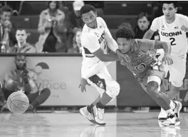  ?? BRAD HORRIGAN/HARTFORD COURANT ?? UConn guard Alterique Gilbert (3) tries to shield UM guard Chris Lykes (0) from a loose ball during the Charleston Classic at TD Arena on Sunday.