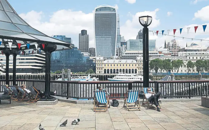  ?? SIMON DAWSON / BLOOMBERG ?? Turistas y empleados de la City comparten descanso frente al emblemátic­o edificio bautizado como ‘walkie talkie’