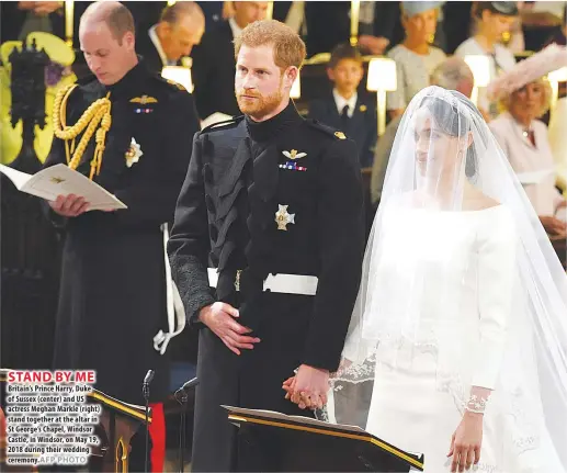  ?? AFP PHOTO ?? STAND BY ME Britain’s Prince Harry, Duke of Sussex (center) and US actress Meghan Markle (right) stand together at the altar in St George’s Chapel, Windsor Castle, in Windsor, on May 19, 2018 during their wedding ceremony.