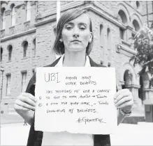  ??  ?? Monika Ciolek, a basic income recipient, poses with a sign saying what the program has meant to her.