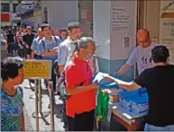  ??  ?? 香港特首林鄭月娥11­日發表施政報告當天，有市民在街頭領取《施政報告》。 （中通社）