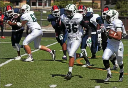  ?? RANDY MEYERS — THE MORNING JOURNAL ?? Elyria Catholic running back Jonah Baker runs left and picks up blockers against host Cleveland Central Catholic on Sept. 9.