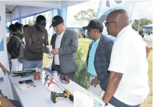  ?? ?? Senator Matthew Samuda, Minister without Portfolio in the Ministry of Economic Growth and Job Creation, listens keenly as plumber Derrick Francis explains how to read the digital meter. Looking on are Dr Norman Dunn (second right), the Member of Parliament for St Mary South Eastern and Dr Morais Guy (right), the Member of Parliament for Central St Mary.