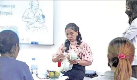  ?? UNICEF CAMBODIA ?? A women shows others how to properly provide breastfeed­ing to a newborn.