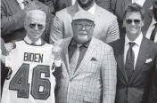  ?? DREW ANGERER Getty Images ?? Tom Brady, right, and Bucs coach Bruce Arians present a team jersey to President Joe Biden on Tuesday.