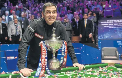  ?? AFP ?? Ronnie O’Sullivan poses with the trophy after his victory in the World Snooker Championsh­ip at the Crucible Theatre in Sheffield on Monday.