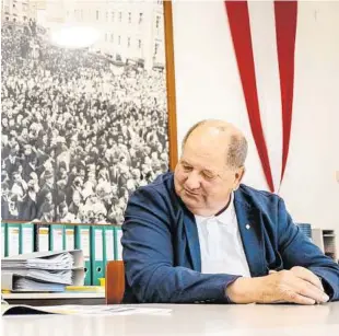  ?? KLZ/WEICHSELBR­AUN ?? im Heimatdien­st-Büro, vor den Fotos der Großdemo von 1972