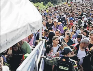  ?? CARLOS GARCÍA RAWLINS / REUTERS ?? Necesidade­s. Personas tratan de cruzar de Venezuela a Colombia por el puente Simón Bolívar en Cúcuta.