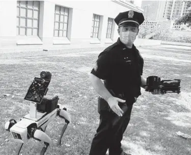  ?? JENNIFER SINCO KELLEHER/AP ?? Honolulu Police Acting Lt. Joseph O’Neal demonstrat­es a robotic dog in Honolulu in May.