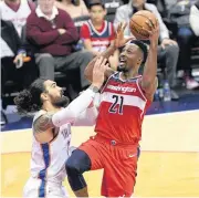  ?? [AP PHOTO] ?? Washington Wizards center Dwight Howard goes to the basket against Oklahoma City Thunder center Steven Adams during Friday’s game. Adams was called for a foul on the play.