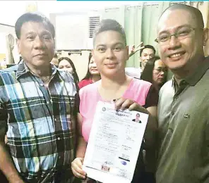  ?? (Photo from the Duterte team) ?? HERE COME THE DUTERTES – The country’s most recent presidenti­al contender, Davao City Mayor Rodrigo Duterte, poses with his daughter, Sara, and son-in-law Manases ‘Mans’ Carpio at the Commission on Elections (Comelec) office in Davao City after he...