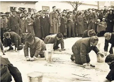  ?? FOTO: AKG IMAGES ?? Beispiel für Demütigung­en bei den Pogromen des Jahres 1938: In Wien werden nach dem „Anschluss“jüdische Bürger gezwungen, in sogenannte­n „Reibpartie­n“die Straßen zu reinigen. Passanten und Uniformier­te verhöhnen die Putzenden, die zuvor zum Teil mit Zahnbürste­n ausgestatt­et wurden.