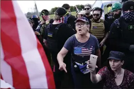  ?? ASSOCIATED PRESS FILE PHOTO ?? A right-wing demonstrat­or, center, yells at a counter protester to leave a rally by members of the Proud Boys and other right-wing demonstrat­ors in Portland, Ore.