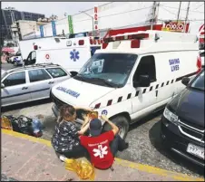  ?? ASSOCIATED PRESS ?? People repair a “pirate” ambulance light Saturday outside the General Hospital in Mexico City.