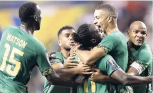  ?? FILE ?? Jamaica’s Darren Mattocks (centre) is embraced by teammates Rodolph Austin (right), Michael Hector (second, right), Je-Vaughn Watson (left) and Adrian Mariappa after Mattocks scored against the United States in the CONCACAF Gold Cup semifinal on July 22.