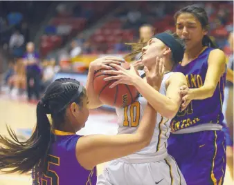  ?? ADOLPHE PIERRE-LOUIS/JOURNAL ?? St. Pius player Gabrielle Aragon, center, tries to escape the trapping defense of Kirtland Central’s Aubrey Thomas, left, and Tiajhae Nez on Tuesday at the Pit. The Broncos came from behind to win.