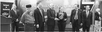  ??  ?? Gladys (third right) receives the ‘Most Promising Writer Award’ trophy from Education Minister Datuk Seri Mahdzir Khalid.