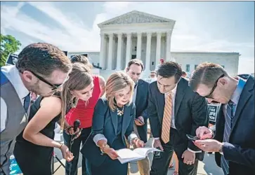  ?? Jim Lo Scalzo EPA/Shuttersto­ck ?? KRISTEN WAGGONER, center, senior vice president with the Christian legal group Alliance Defending Freedom, reads the Supreme Court ruling, which sided with antiaborti­on pregnancy centers in California.