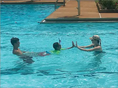  ?? Staff photo by Ashley Gardner ?? ■ Oakley Ward gets help learning to swim Monday afternoon from volunteers Layton Lammers, left, and Sophia Zaeringer at the Texarkana Country Club pool.