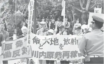  ??  ?? Anti-nuclear demonstrat­ors stage a rally in front of the Nuclear Regulatory Authority (NRA) in Tokyo. — AFP photo