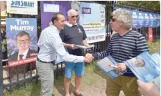  ?? — AFP ?? Liberal Party candidate for Wentworth Dave Sharma (L) greets voters outside a polling station during the Wentworth by-election in Bondi Beach in Sydney on Saturday.