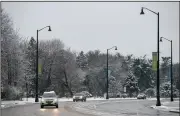  ?? (AP/Rockford Register Star/Scott P. Yates) ?? Traffic moves along a slushy road Tuesday in Rockford, Ill. The National Weather Service office in Chicago reported that 1.7 inches of snow fell in the area.