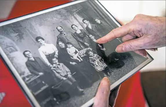  ?? Alexandra Wimley/Post-Gazette photos ?? Ruth Drescher holds a portrait of her family, taken before she and her parents fled Germany in August 1939. She is pointing out her mother, Gerty.