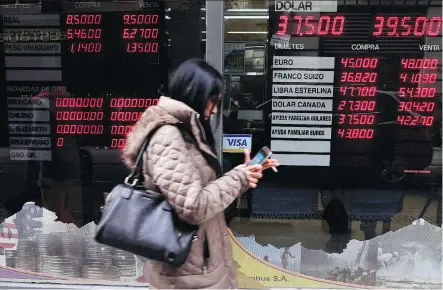  ?? EITAN ABRAMOVICH/AFP ?? Currency exchange values are displayed in the bureau de exchange in Buenos Aires. Argentina’s peso began to recover on Friday as markets opened, making a tiny 0.68 per cent gain after losing 20 per cent of its value against the dollar during the previous two days.