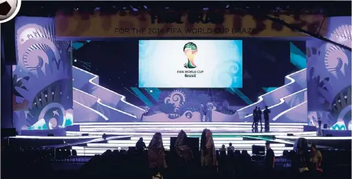  ?? AP ?? Workers stand on the stage where the 2014 soccer World Cup draw will take place in Costa do Sauipe, Brazil, today.