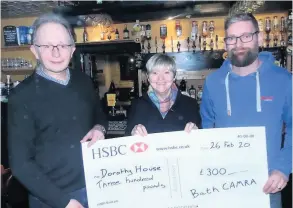  ??  ?? Trevor Cromie, left, Chris Powell, landlord of The Royal Oak , right, present a cheque to Yvonne Brunton from Dorothy House
