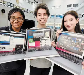  ?? JOHN RENNISON THE HAMILTON SPECTATOR ?? From left, students Vanessa Memeh, Noah Drzewicki, and Paige Wallace with the school’s 202021 yearbook. The yearbook was delayed because of COVID-19.