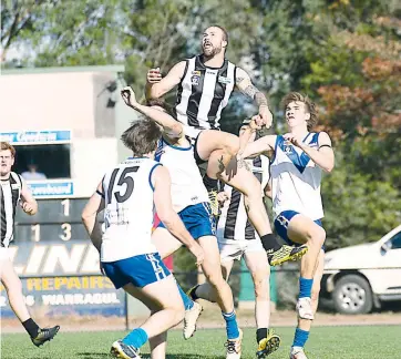  ??  ?? Patrick Harmes flies high above the pack during the first quarter of action at Neerim South.