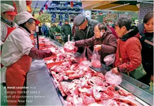  ??  ?? A meat counter in a Jiangsu market sees a rush of customers before Chinese New Year