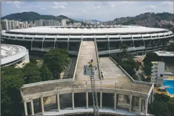  ??  ?? Backdroppe­d by Maracana stadium, firefighte­r Elielson Silva plays his trumpet April 5 from the top of a ladder for residents at home, during a lockdown to help contain the spread of the coronaviru­s in Rio de Janeiro, Brazil.
(File Photo/AP/Leo Correa)