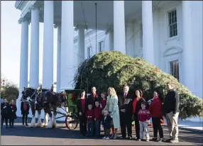  ?? (AP/Alex Brandon) ?? First lady Jill Biden (center) with Beau Biden, poses for a photo with the Shealer family as the White House Christmas Tree arrives on Monday in Washington. The concolor fir tree for the Blue Room of the White House is 18 and one half feet tall, and is presented by the Shealer Family of Evergreen Acres Christmas Tree Farm in Auburn, Pa.