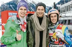  ??  ?? Zwei Weitenjäge­r und ein Torschütze: Die Skispringe­r Andreas Wellinger (links) und Stefan Kraft (rechts) mit Bayern Stürmer Robert Lewandowsk­i.