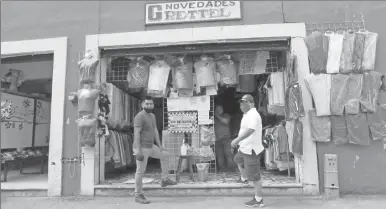  ??  ?? Una tienda de guayaberas y ropa tradiciona­l en espera de clientes, ayer en Valladolid . Las medidas de higiene se informan en la entrada