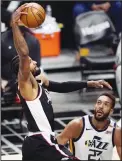  ?? (AP) ?? Los Angeles Clippers guard Paul George, (left), dunks as Utah Jazz center Rudy Gobert watches during the second half of Game 3 of a second-round NBA basketball playoff series, on June 12, in Los Angeles.