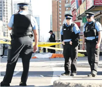  ?? NATHAN DENETTE, THE CANADIAN PRESS ?? Police secure an area around a covered body in Toronto after a van mounted a sidewalk and crashed into a number of pedestrian­s on Monday.