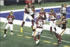  ?? ASSOCIATED PRESS ?? WASHINGTON FOOTBALL TEAM’S MONTEZ SWEAT (second from left) and Ryan Kerrigan (91) celebrate Sweat’s intercepti­on of a pass by Dallas Cowboys’ Andy Dalton that Sweat ran back for a touchdown during the second half of a game in Arlington, Texas, on Thursday.