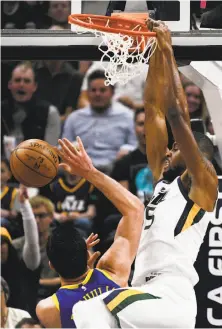  ?? Alex Goodlett / Associated Press ?? Derrick Favors of the Jazz dunks over Warriors center Zaza Pachulia in the first half of Utah’s rout of Golden State.